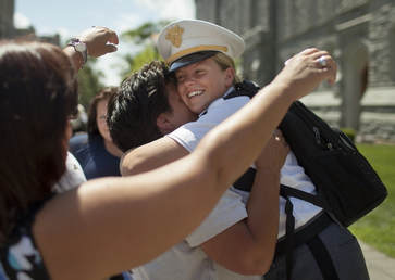 Young girl in military hat hugging her mom