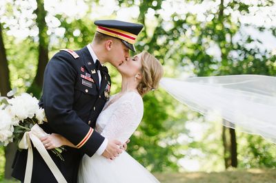 Bride and groom kissing amid forested landscape